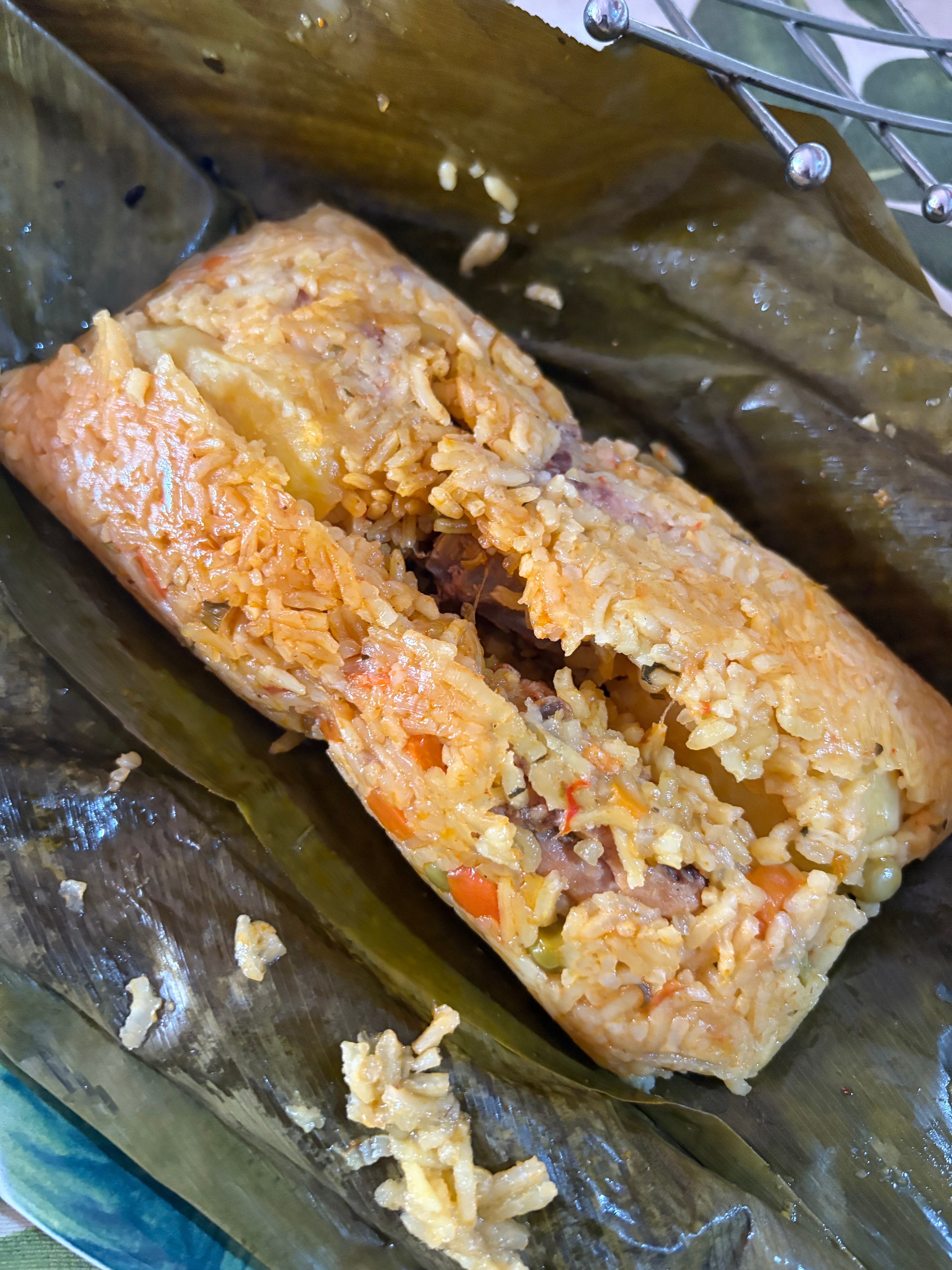 Unwrapped tamale showing the filling inside banana leaf
